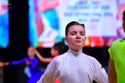 Dancesport competitor: Foreground dancer: white long-sleeved turtleneck top