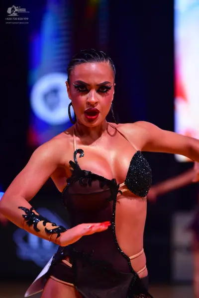 Dancesport competitor: Female dancer: black and nude-colored Latin dance costume with sheer mesh, black