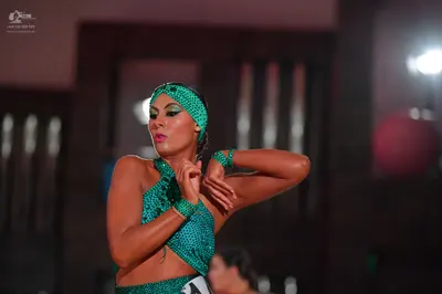 Dancesport competitor: Female dancer: teal sequined Latin dance costume including a crop top, matching 