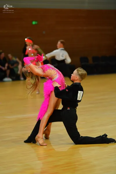 Dancesport competitor: ** Red Latin Dress
*   **Color:** Primarily red 
*   **Fabric:** Appears to be a