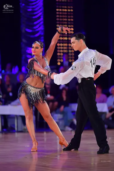 Dancesport competitor #148: Male dancer: white long-sleeved Latin shirt with small sparkly embellishments an