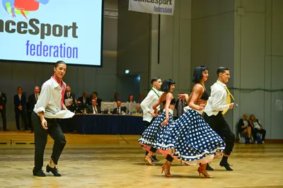 Dancesport competitor: Male dancers: white long-sleeved shirts, black trousers, and black dance shoes; 