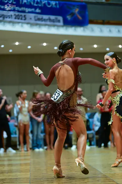 Dancesport competitor #53: Female dancer 1: maroon long-sleeved Latin dress with an open back and dark maro