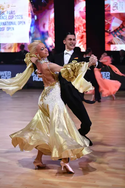 Dancesport competitor: Female dancer: shimmering gold ballroom dress with a heavily embellished bodice 