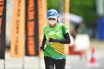Marathon runner: Runner 1: light blue cap, white face mask, green jersey with yellow patterns, bl