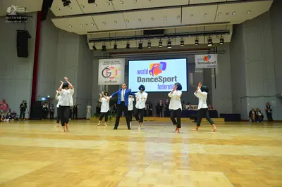 Dancesport competitor: All female dancers wear white long-sleeved tops and black pants