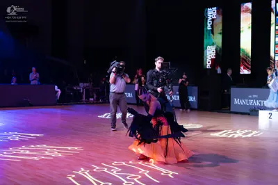 Dancesport competitor: Female dancer: orange and black ballroom gown with a voluminous skirt and dark f