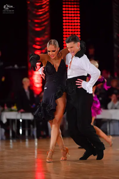 Dancesport competitor: Male dancer: white long-sleeved shirt and black trousers with black gloves