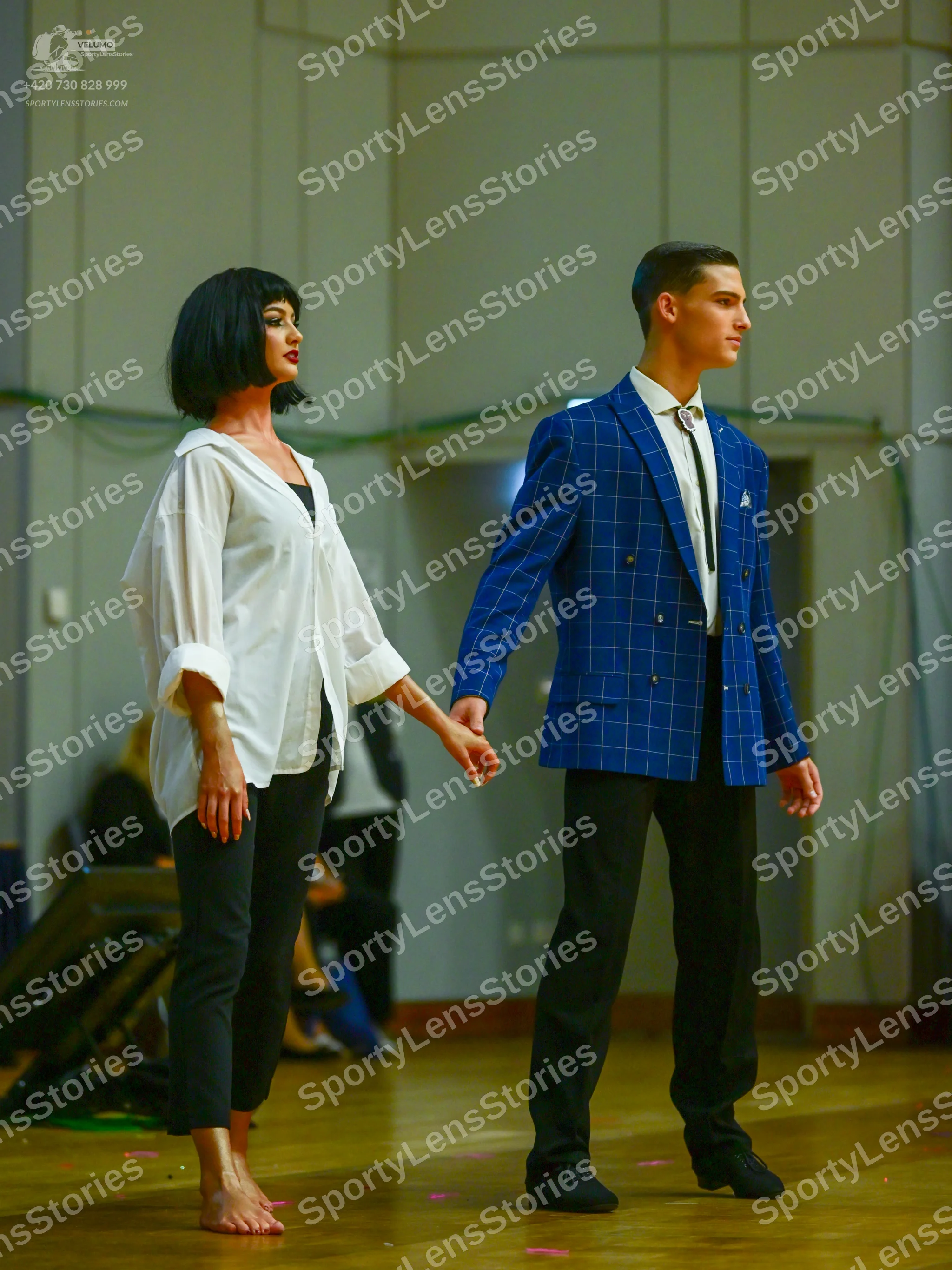 Dancesport competitor: Male dancer: blue windowpane pattern suit jacket, white shirt, dark tie, black t