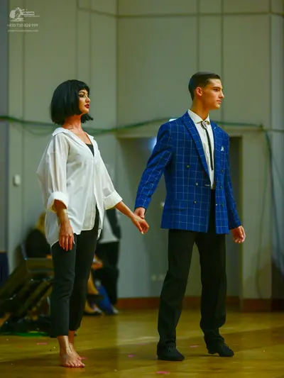 Dancesport competitor: Male dancer: blue windowpane pattern suit jacket, white shirt, dark tie, black t