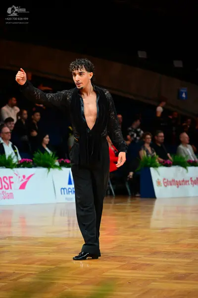 Dancesport competitor: Male dancer: black textured long-sleeved shirt with a deep V-neck and black trou