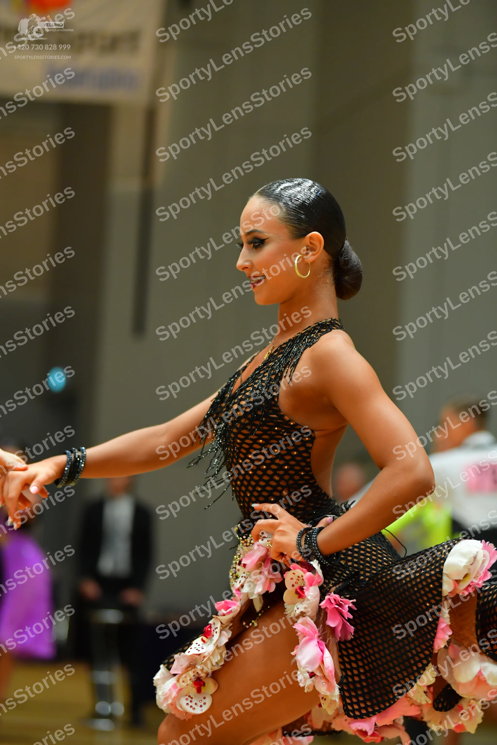 Dancesport competitor: Female dancer: black mesh Latin dress decorated with large 3D fabric flowers in