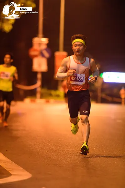 Marathon runner #42185: Runner 1: orange tank top, black shorts, yellow shoes, yellow headband