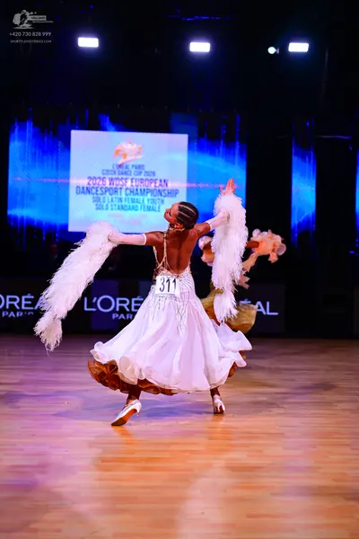 Dancesport competitor: Female dancer (foreground): white ballgown with large white feathered arm accent