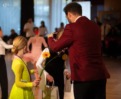 Dancesport competitor: Female dancer: bright yellow long-sleeved ballroom dress with a smooth, satin-li