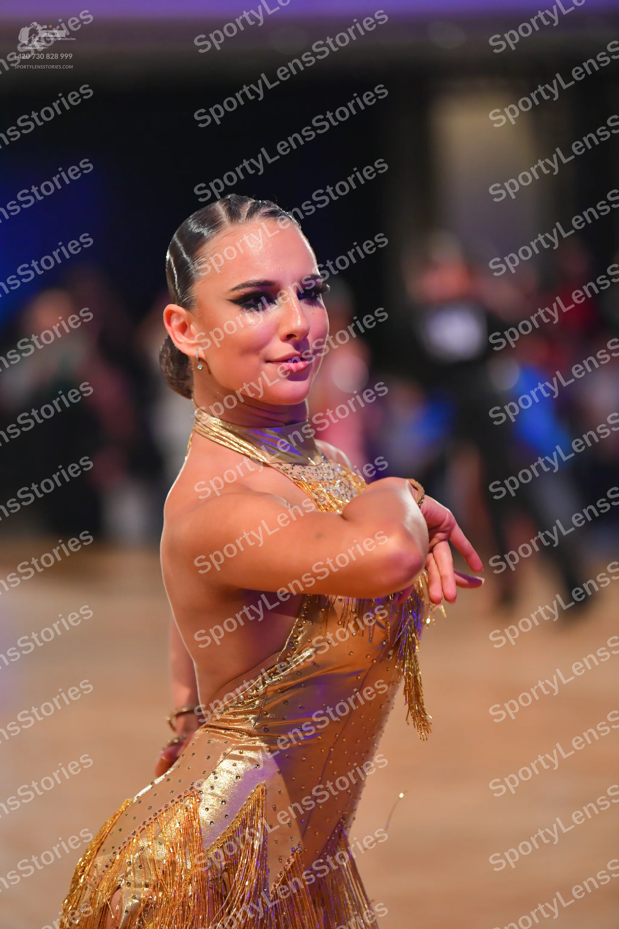 Dancesport competitor: Female dancer: gold latin dress with sequin embellishments and long fringe