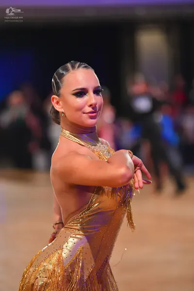 Dancesport competitor: Female dancer: gold latin dress with sequin embellishments and long fringe