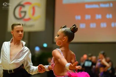Dancesport competitor: Male dancer: white long-sleeved shirt and black trousers with a black belt
