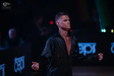 Dancesport competitor: Male dancer: black, long-sleeved, open-chested Latin dance shirt with subtle spa