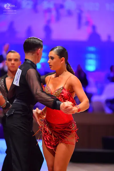 Dancesport competitor: Male dancer: black long-sleeved shirt with sheer sleeves and black trousers
