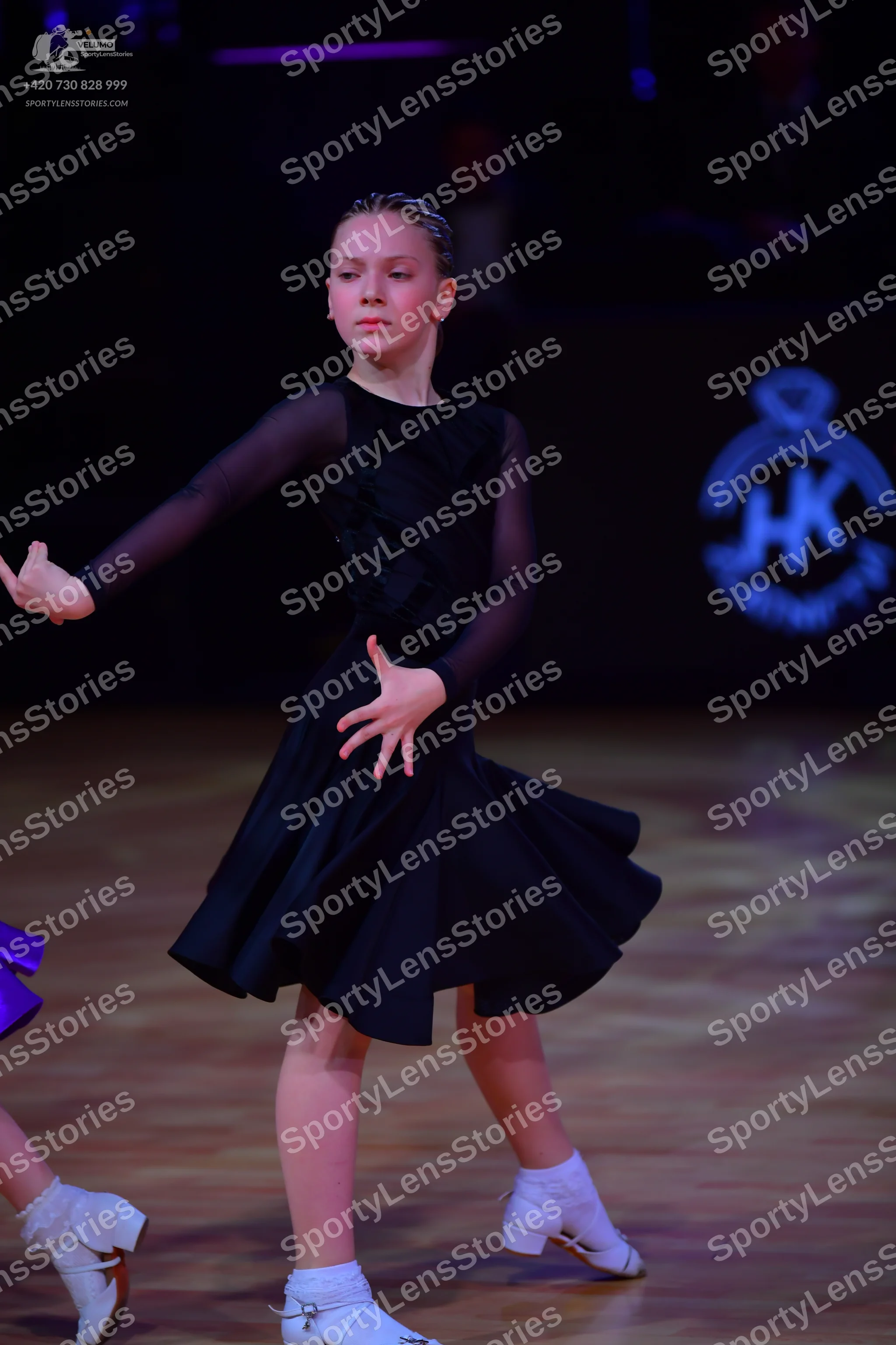 Dancesport competitor: Female dancer: black long-sleeved dress with a flared skirt and sheer mesh sleev