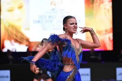 Dancesport competitor: Female dancer: blue latin dress with gold sequins and blue fringe