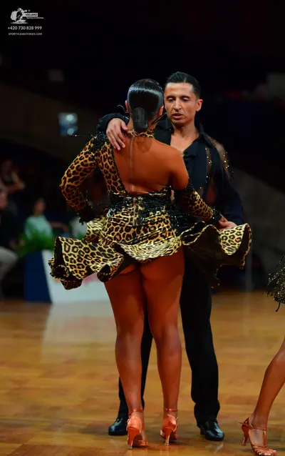 Dancesport competitor: Female dancer: leopard print Latin dance dress with long sleeves and a low back,