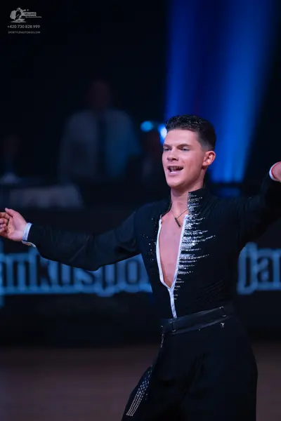 Dancesport competitor: Male dancer: black long-sleeved top with vertical silver sequin stripes down the