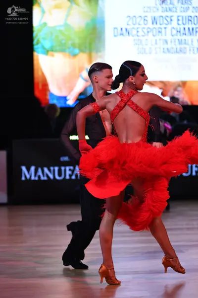 Dancesport competitor: Female dancer: red latin dress with a red sequined bodice and a large, voluminou