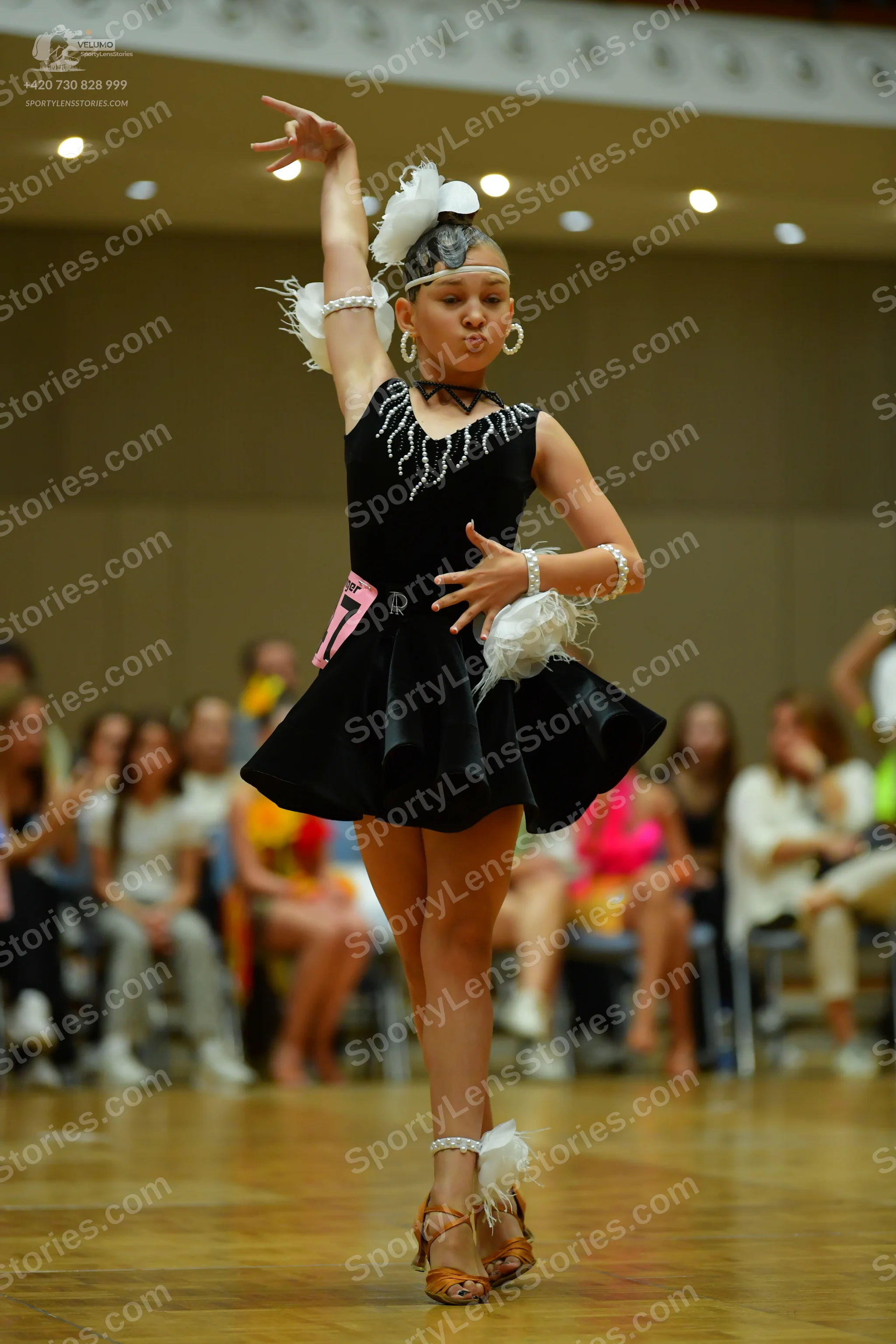 Dancesport competitor: Female dancer: black latin dress with silver/white beadwork around the neckline,