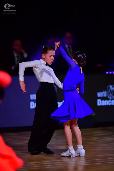Dancesport competitor: Male dancer: white long-sleeved shirt, black trousers, and a black bowtie