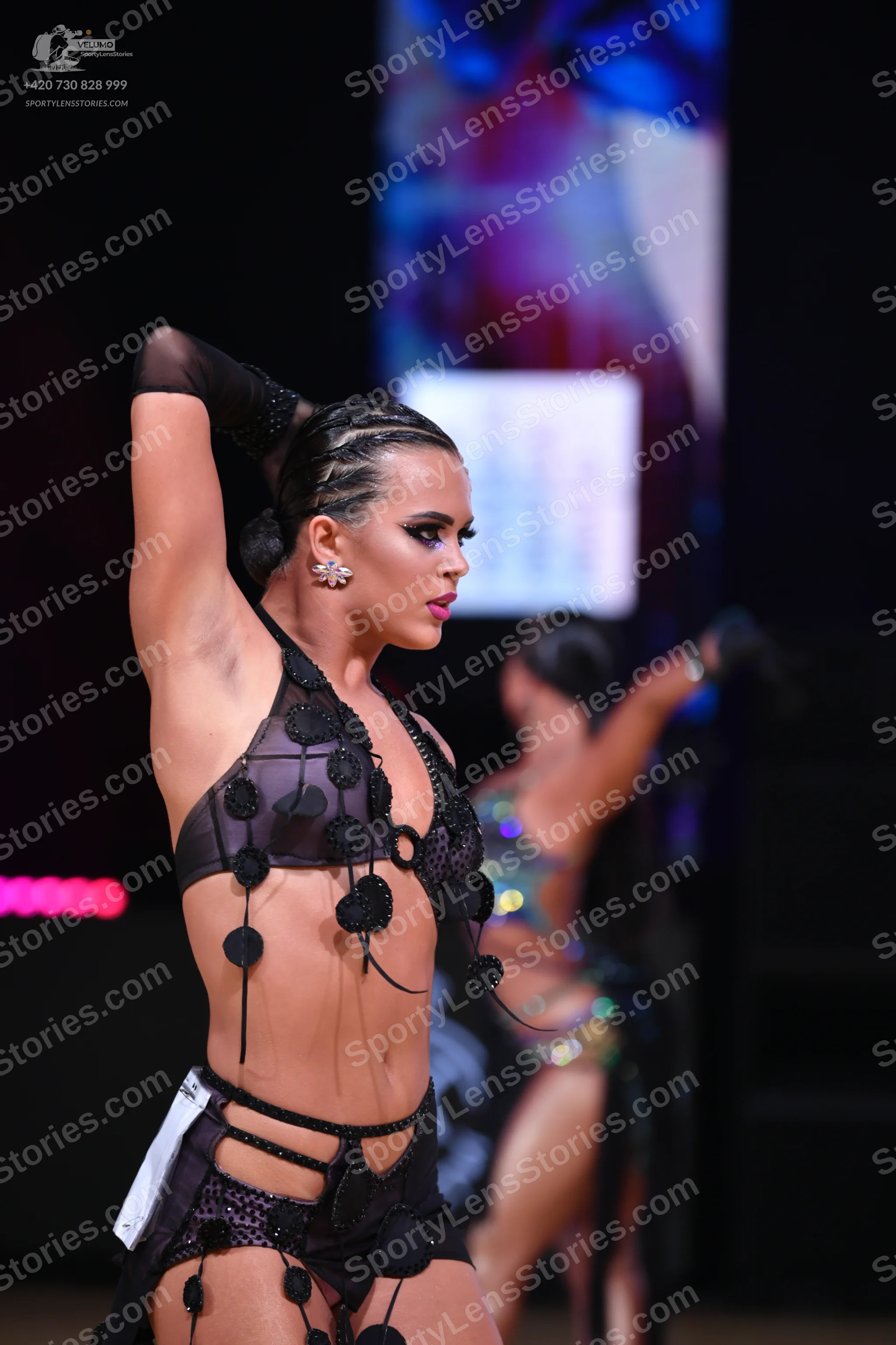 Dancesport competitor: Main female dancer: black Latin dance costume featuring sheer mesh, thin straps,