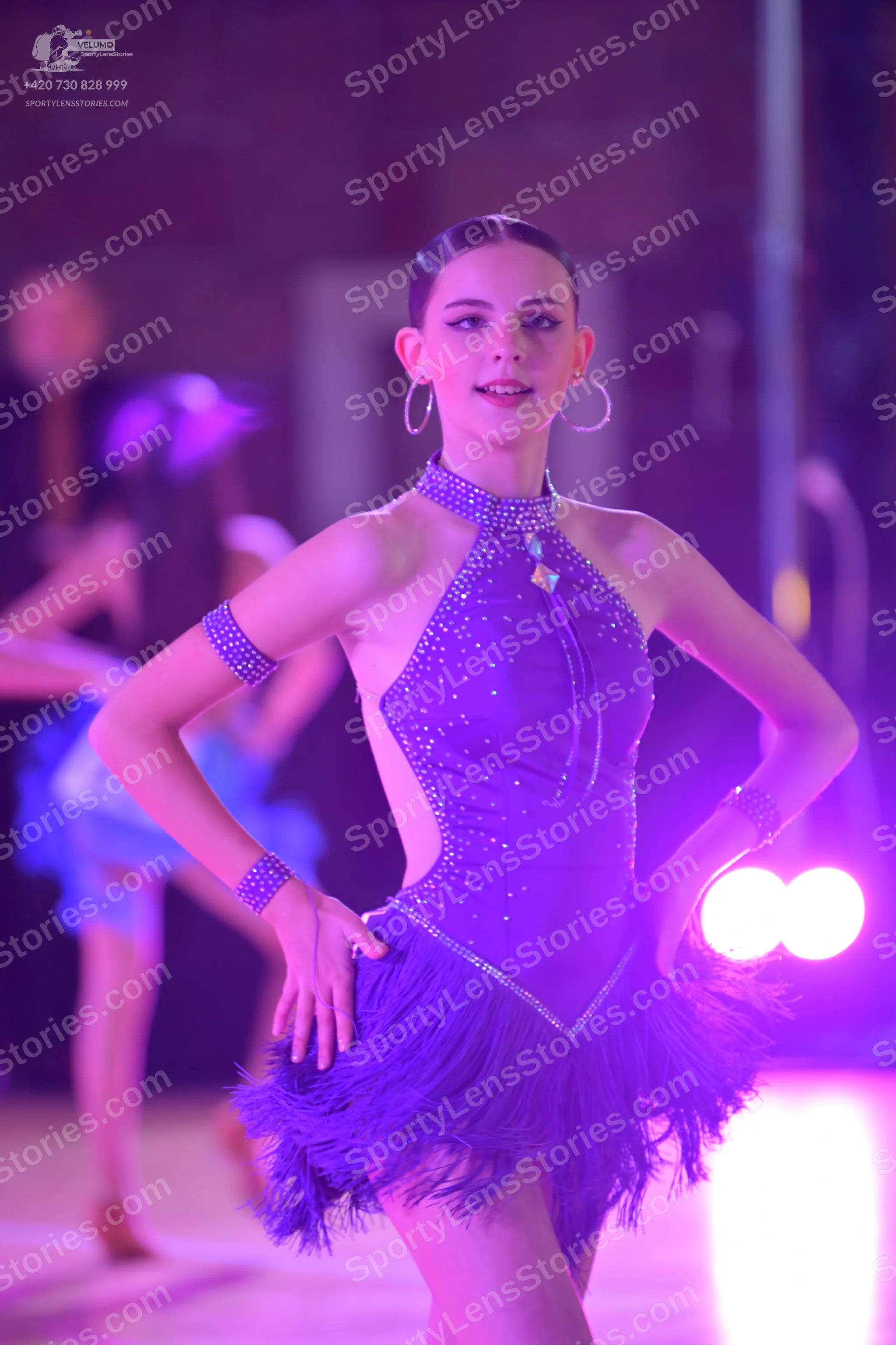 Dancesport competitor: Female dancer: purple latin dress with sequins, halter neck, side cutouts, and a