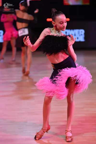 Dancesport competitor: Dancer in background: black latin outfit