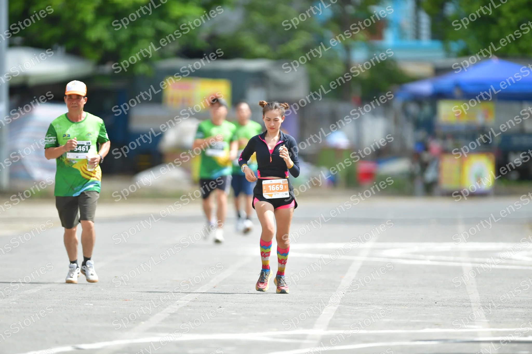 Marathon runner #546, #10559: Runner 1: green jersey, grey shorts, white cap, white shoes