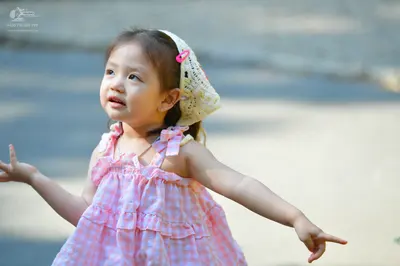 Dancesport competitor: Female child: pink and white gingham sleeveless dress with ruffled straps and a 