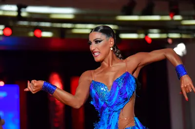 Dancesport competitor: Female dancer: blue latin dress with sequins and long fringe, featuring matching