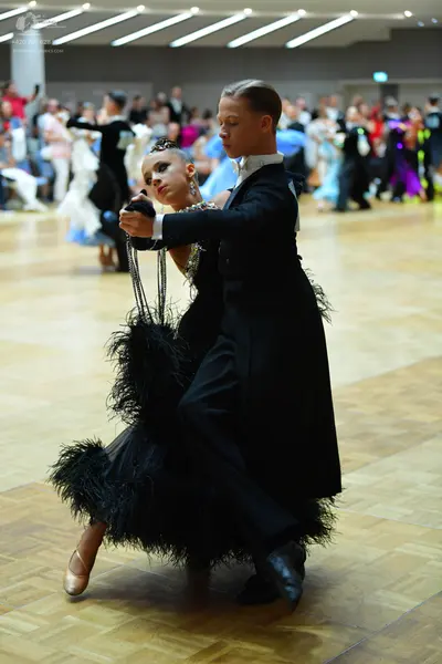 Dancesport competitor: Male dancer: black ballroom suit with black trousers and black dance shoes