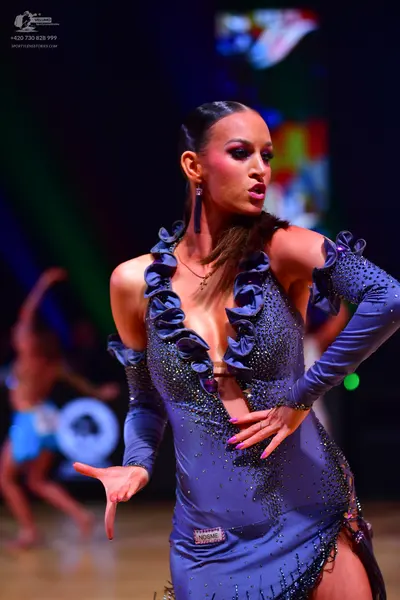 Dancesport competitor: Female dancer: slate blue Latin dance dress with long sleeves, a deep V-neckline
