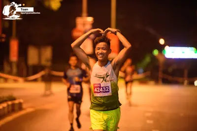 Marathon runner #42432: Runner 1: light-colored sleeveless jersey with green text, yellow shorts