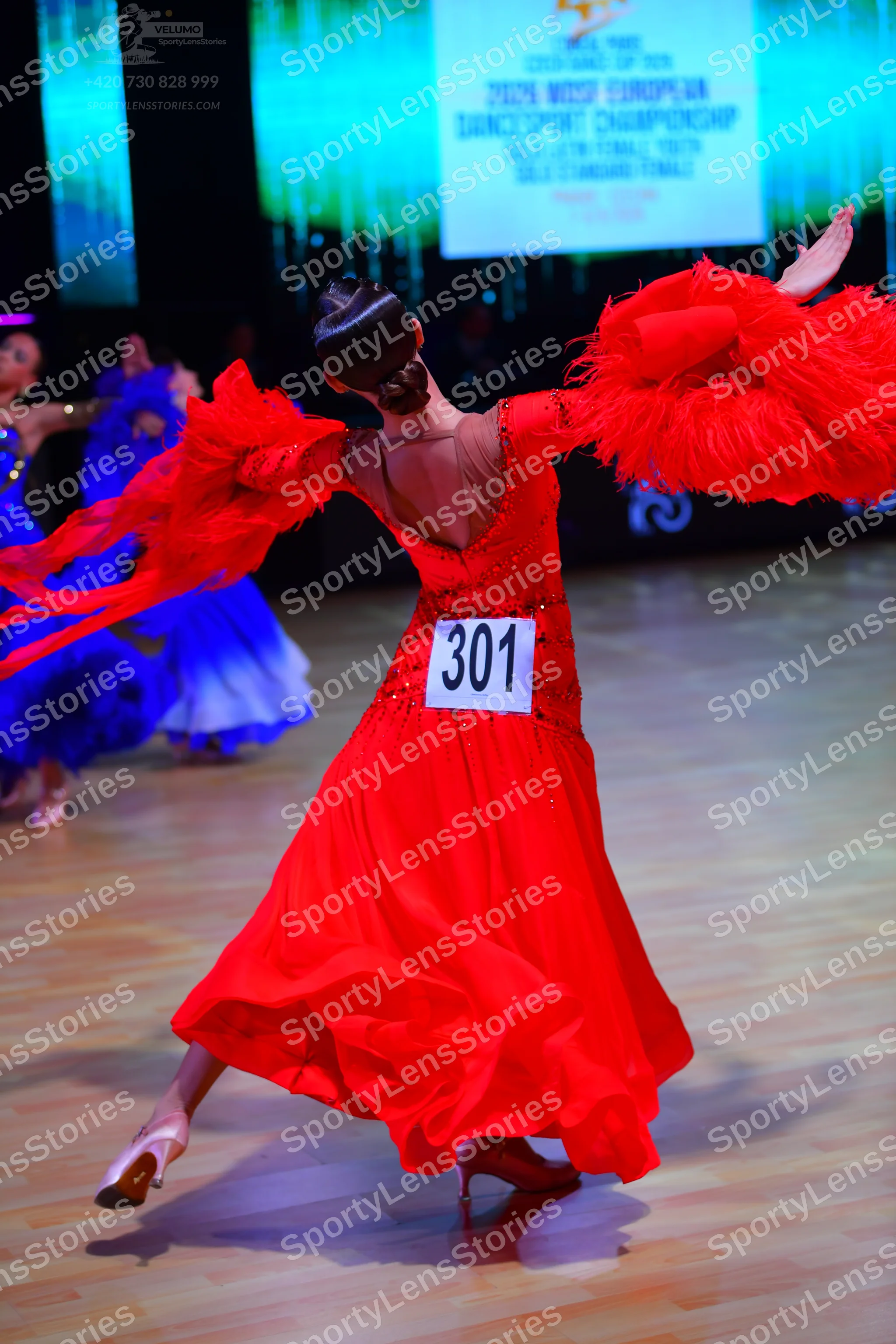 Dancesport competitor: Female dancer: red ballroom gown with a sequined bodice and large, voluminous, r