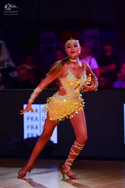 Dancesport competitor: Female dancer: yellow/gold Latin dress with sequins and metallic coin fringe, fe