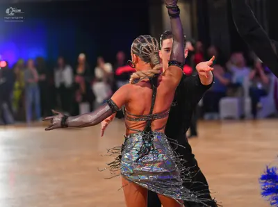 Dancesport competitor: Female dancer: shimmery silver/iridescent latin dress with long fringe and thin 
