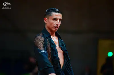 Dancesport competitor: Male dancer: black Latin dance shirt with ruffled front and mesh sleeve