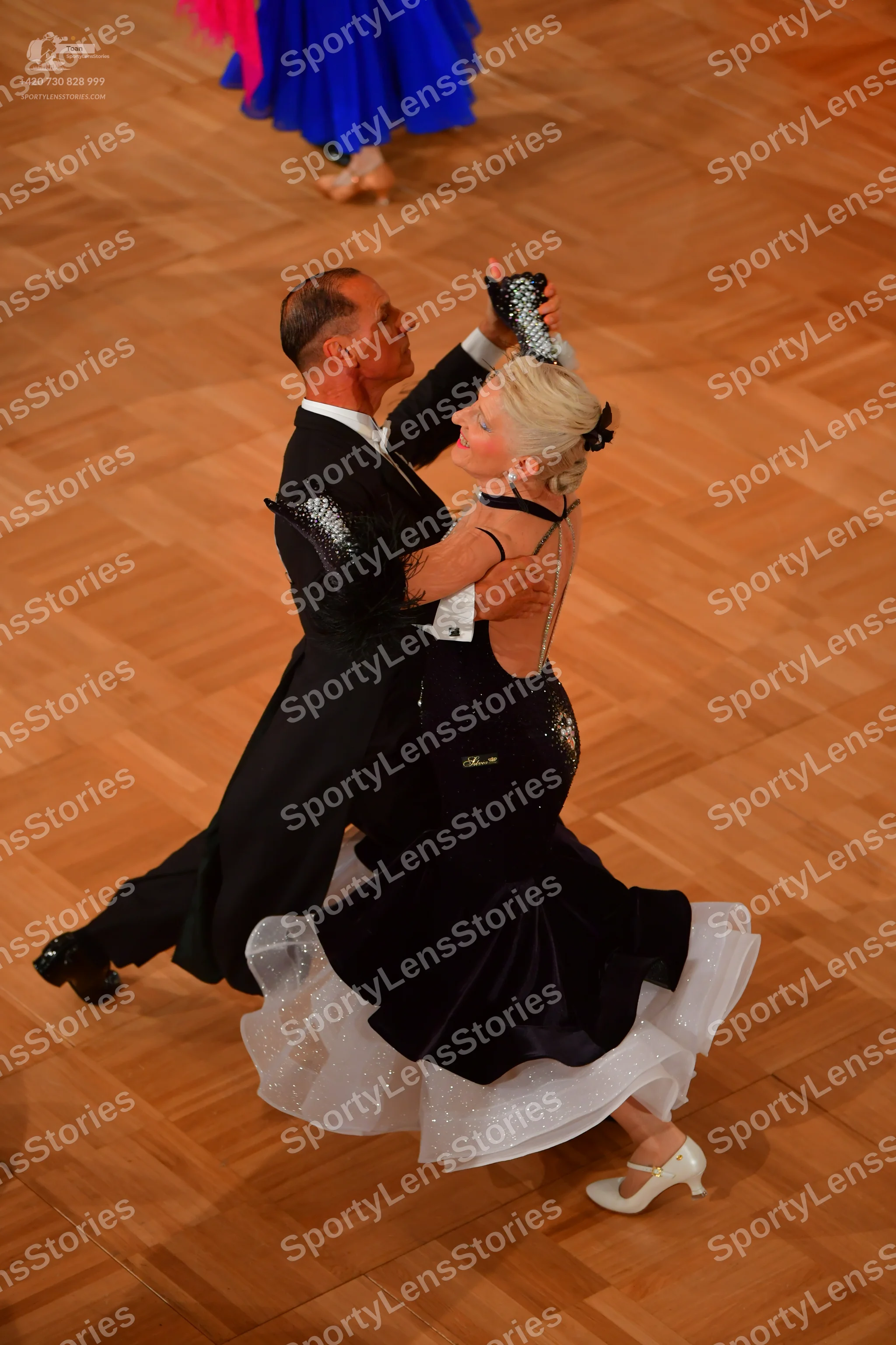 Dancesport competitor: Male dancer: black suit, white shirt, black gloves with silver sequins, and blac
