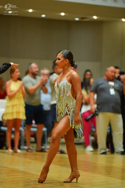 Dancesport competitor: Female dancer: silver and gold sequined Latin dress with fringe