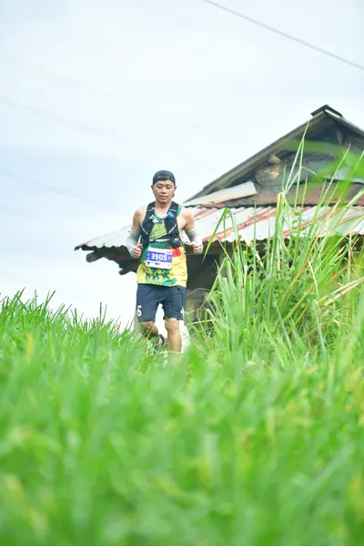 Marathon runner #105: Runner 1: multi-colored jersey, black shorts, white socks, white shoes, dark cap