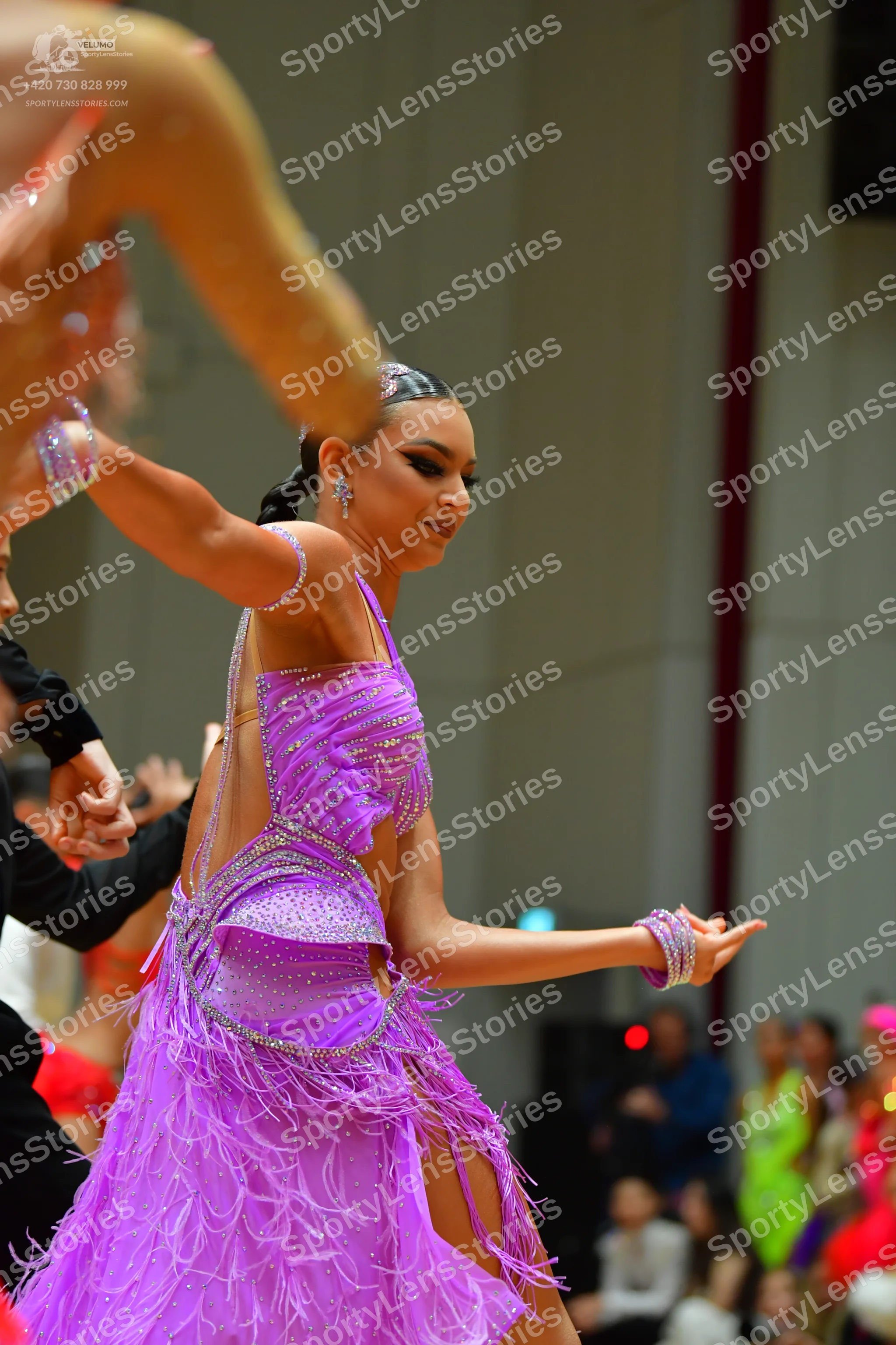 Dancesport competitor: Female dancer: purple Latin dress with a sequined bodice and long fringe skirt