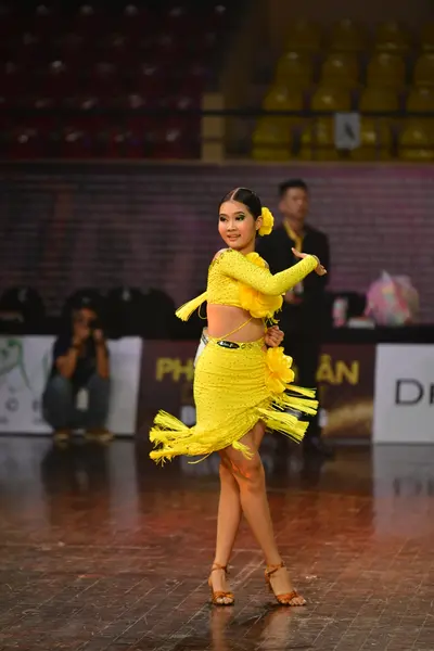 Dancesport competitor: Female dancer: yellow Latin dance dress with fringe and long sleeves
