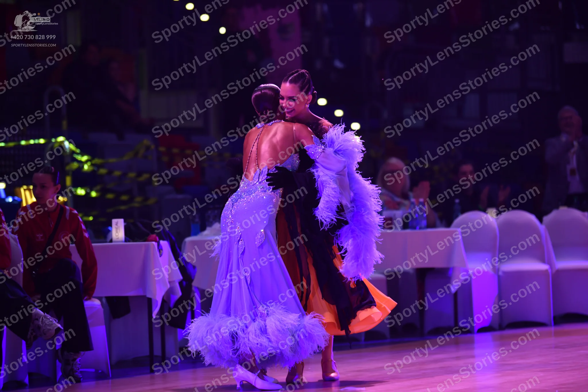 Dancesport competitor: Dancer in light blue: light blue ballgown with large white feathery trim at the 